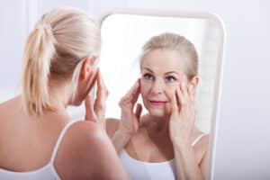 Mature female facelift patient caring for her procedure's results.