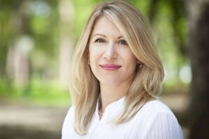 Woman with smooth, youthful face in natural light, representing five-year facial fat transfer results.